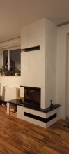 Teplovdzušný krb s krbovou vložkou Defro Home INTRA SM BL MINI, plášť krbu s kalcium silikátových desek, žulový parapet Nero Zimbabwe, typové rohové ventilační otvory.